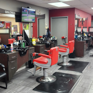 Red barber chairs and styling stations inside Empire Barber Shop
